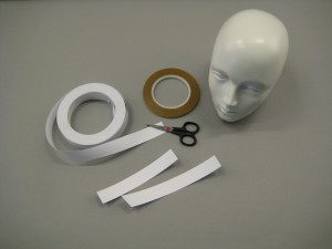 Mannequin head, scissors, paper tape and sticky tape. 